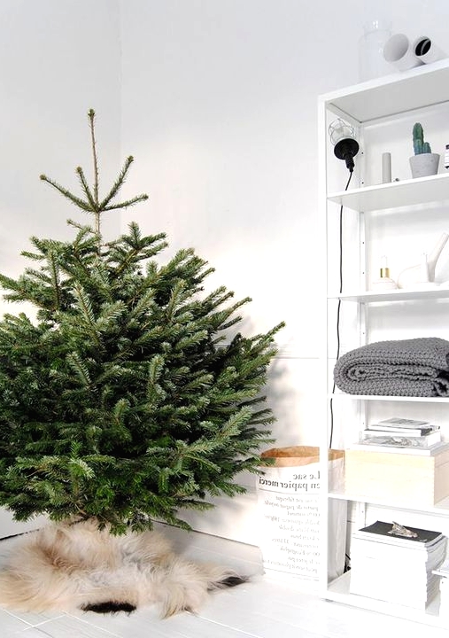 a minimalist Scandinavian Christmas tree with no decor and only faux fur to cover the base is a gorgeous idea to rock
