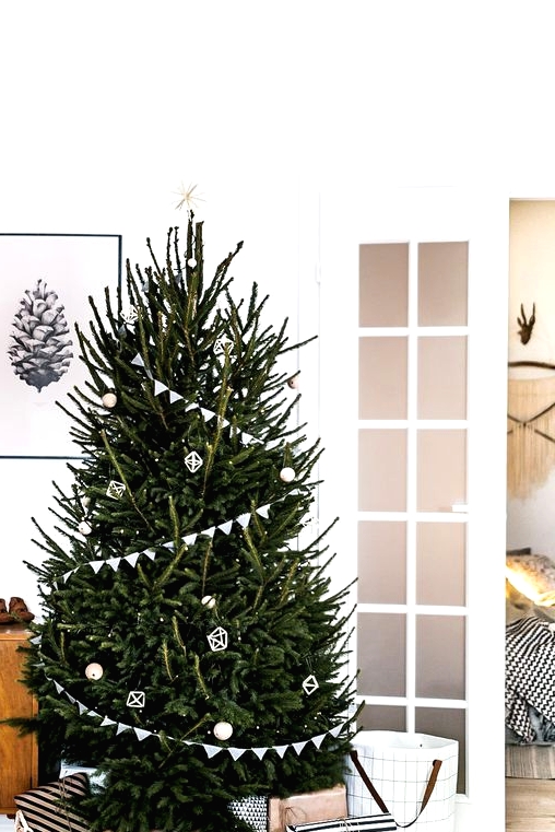 a minimalist Scandinavian Christmas tree with white buntings, lights and just several white ornaments is all you need as less is more