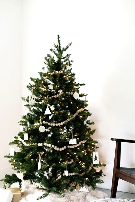 a modern Nordic Christmas tree with lights, wooden beads, white clay ornaments and baubles is a stylish idea