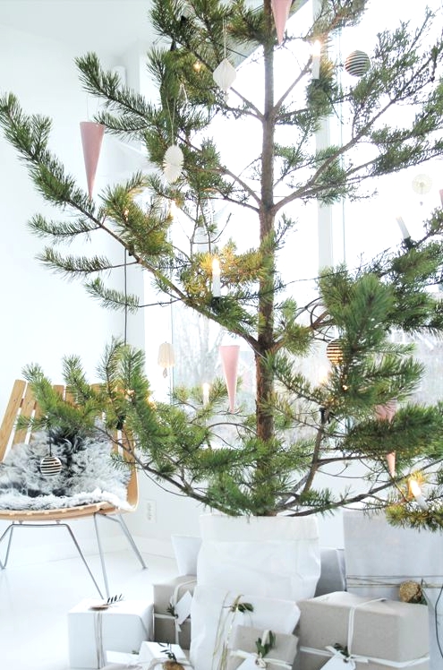an oversized potted pine tree with black and white ornaments plus lights is a lovely idea for a serene modern or Scandi space