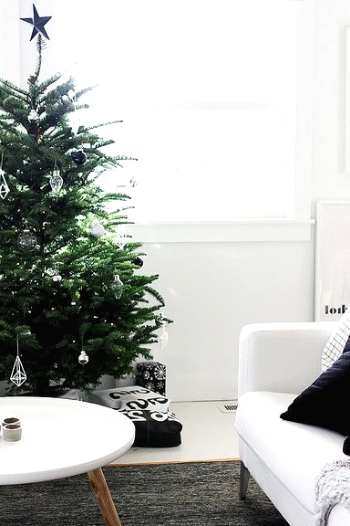 a Christmas tree with black, white and clear glass ornaments is a pretty idea for a modern space and it looks amazing