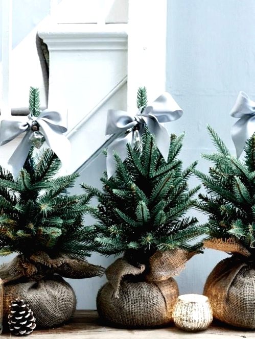 mini Christmas trees in burlap, with grey ribbons bows are a lovely idea for a modern farmhouse space and will do for a mid-century modern home
