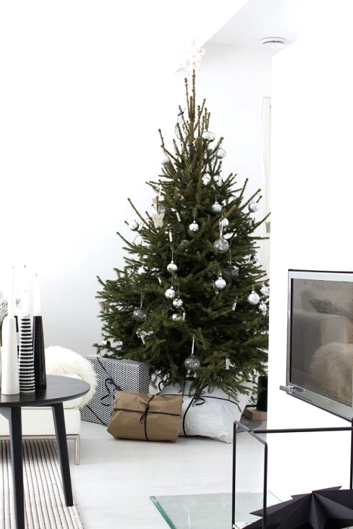 a simple Christmas tree decorated with only sheer and silver Christmas ornaments is a lovely idea for a minimalist or Scandi space