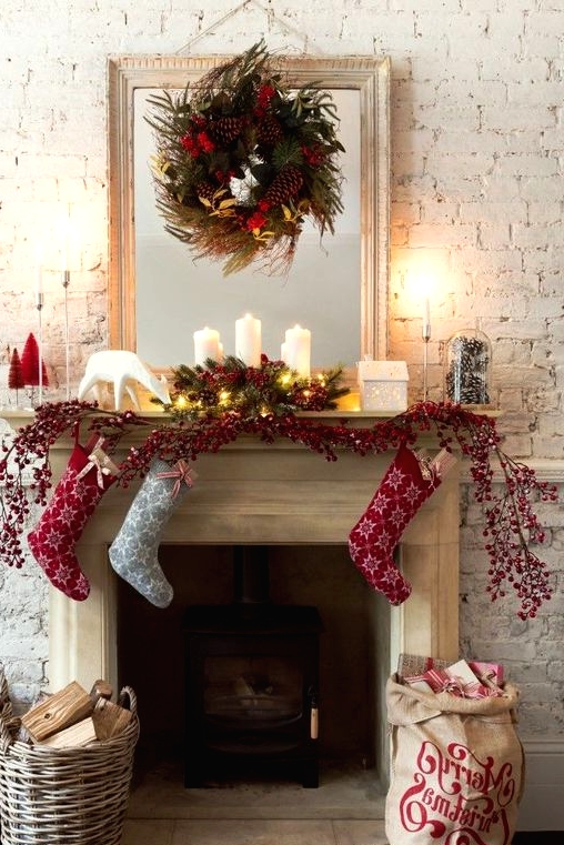 Christmas decor done with baskets, with pillar candles, evergreens, pinecones, red berries and red and grey printed Christmas stockings