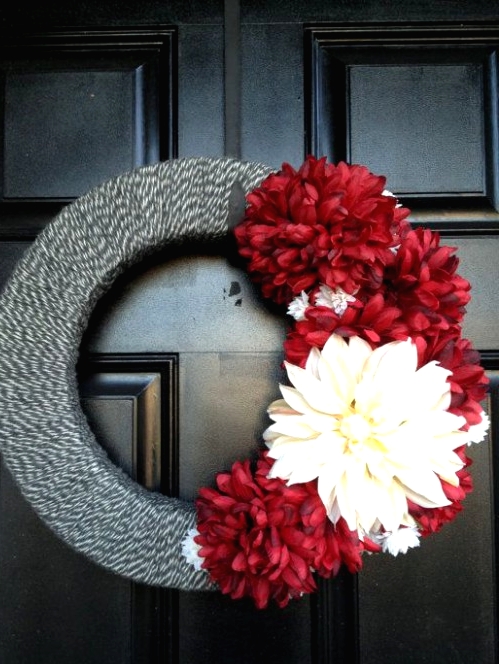 a grey yarn wrapped wreath with red and white blooms is a great decoration for Christmas, and you can easily DIY it