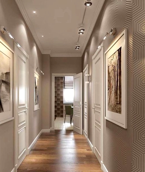 a refined greige corridor with beautiful artworks on the walls and lights and spotlights is a chic and elegant space