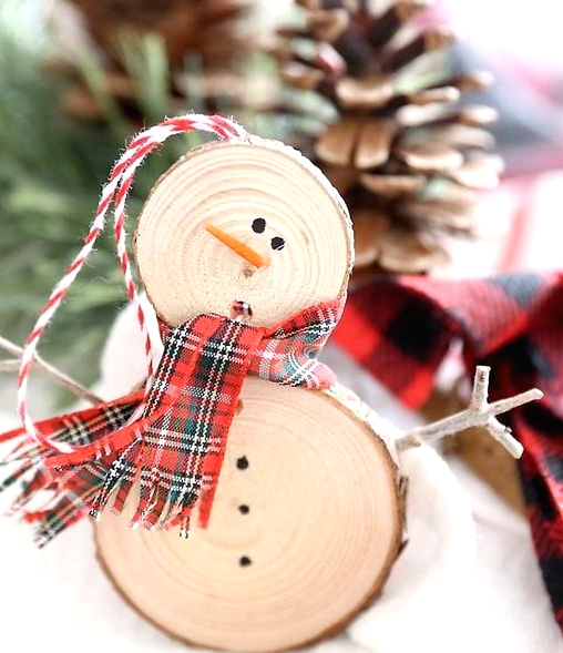 a rustic snowman Christmas ornament with a plywood scarf and yarn is a cool decoration you can DIY