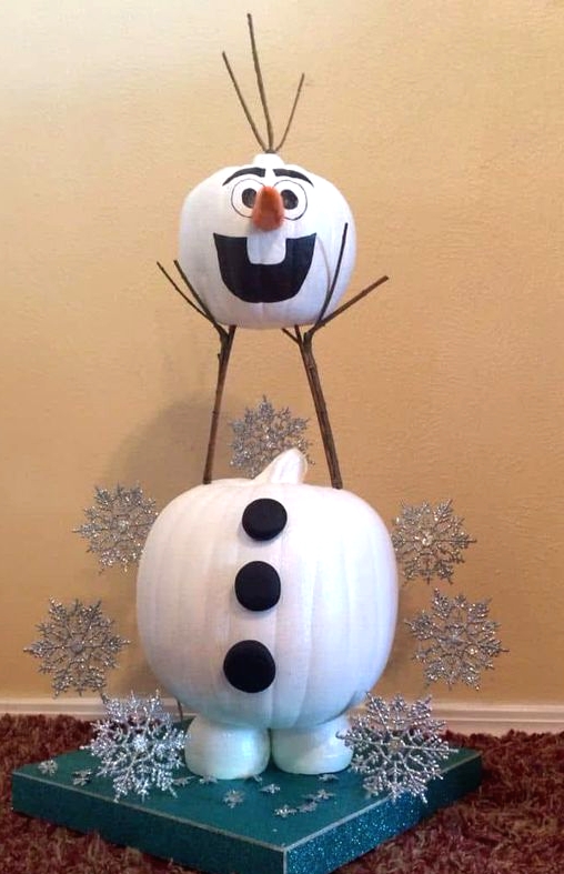 an Olaf snowman of pumpkins painted, with silver snowflakes around and some branches is a cool Disney themed decor idea