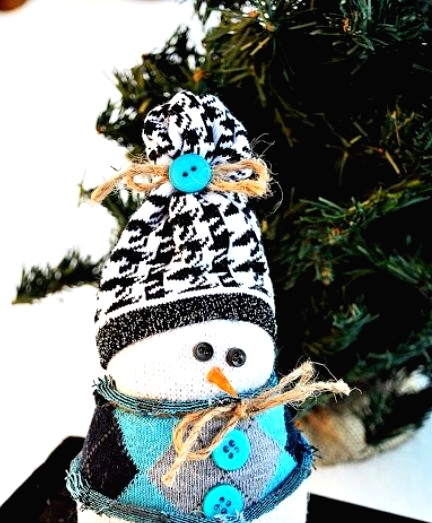 a pretty snowman decoration made of a sock, with a printed hat and a mini sweater with buttons is a lovely idea for Christmas
