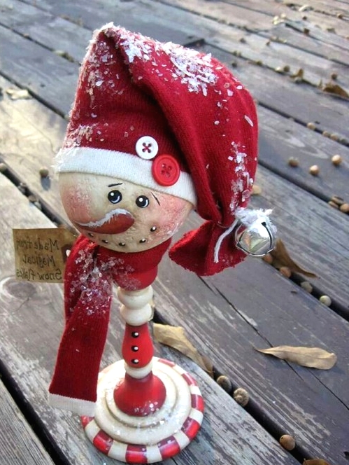 a vintage snowman head decoration of on a stand and with a large red hat is a pretty solution to rock at Christmas