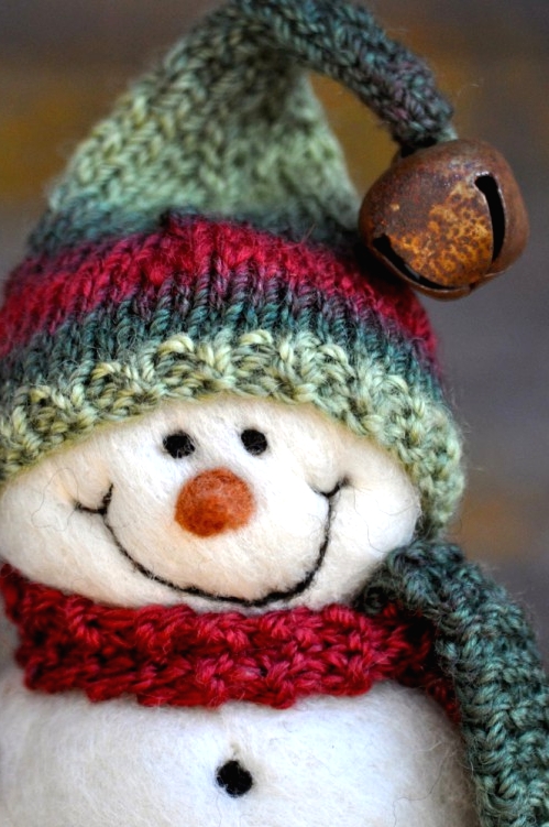a white felt snowman in a red scarf, a green and red hat with a jingle bell is a very cute Christmas ornament you can make yourself