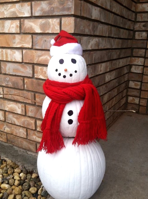 an outdoor snowman decoration made of white pumpkins, buttons, a red scarf and a red hat is a cool idea for a winter space