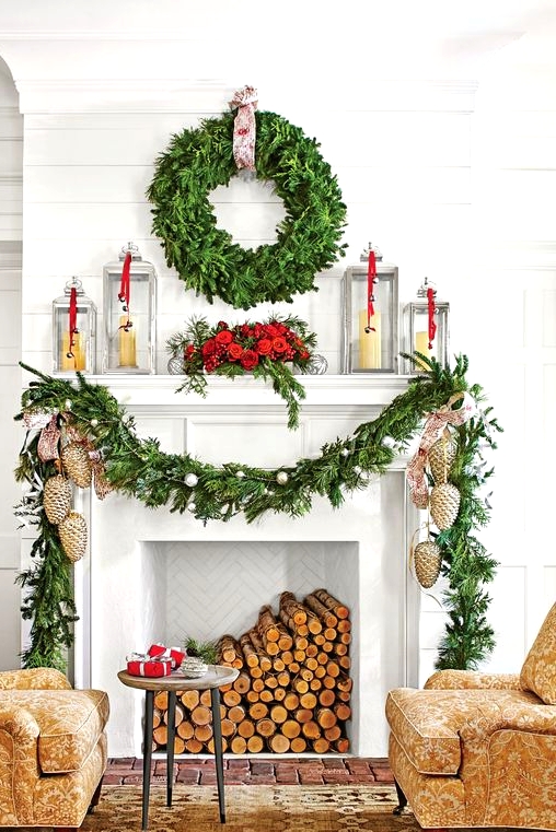 an elegant Christmas mantel with an evergreen garland, ornaments, pinecone ornaments, candles in candle lanterns and an evergreen wreath