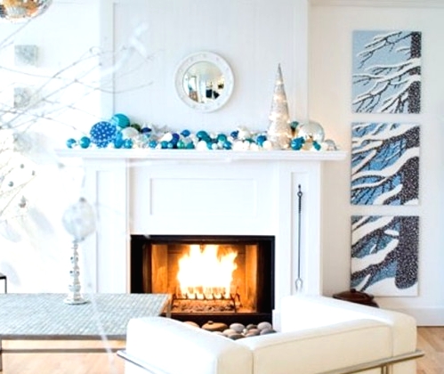 a beautiful frozen Christmas mantel in icy blues and white, with lots of ornaments of various sizes and a faux Christmas tree