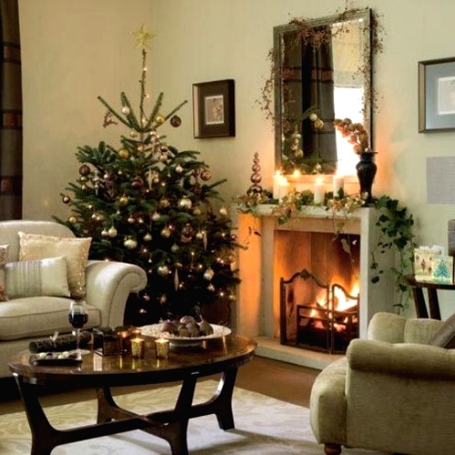 a Christmas mantel styled with a greenery garland, pillar candles and some lights, a branch with ornaments