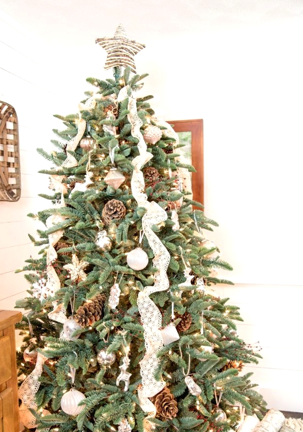 a lovely rustic or woodland Christmas tree with lace ribbons, pinecones, white ornaments, lights and animal-shaped figurines
