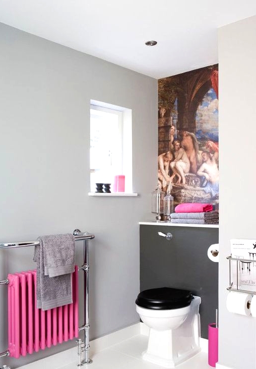 a pretty bathroom with a grey wall, a bold artwork, a vintage toilet, a bold pink radiator and some accessories that echo with it