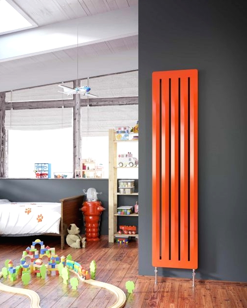 an attic kid's room with grey walls, simple modern furniture, a vertical orange radiator is a lvoely space with a touch of color