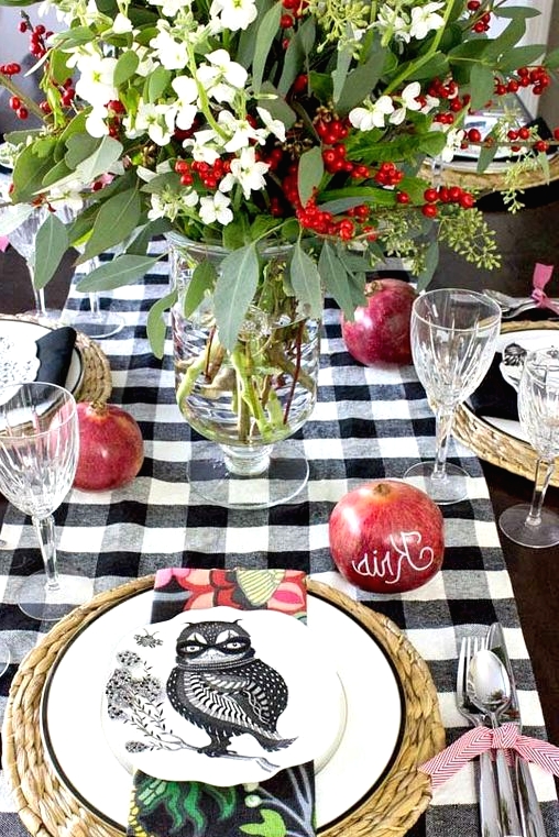 a woven placemat, a white plate with a black rim and a black and white owl printed plate plus a colorful napkin for a bold fall or Thanksgiving tablescape