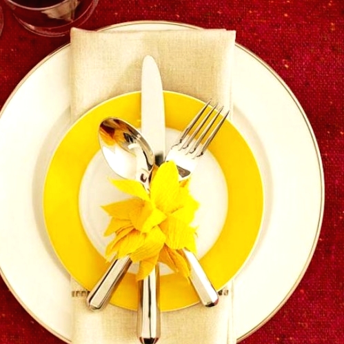 a large white and a mustard and white plate paired with a neutral napkin for a modern Thanksgiving place setting with a touch of color