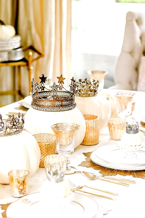 a fabulous glam Thanksgiving tablescape with white pumpkins with crowns, gold chargers and candleholders, mini pumpkins with crowns