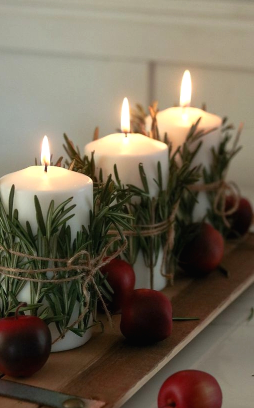 a planked board with candles wrapped with herbs and some faux apples is a great decor idea for fall and Thanksgiving