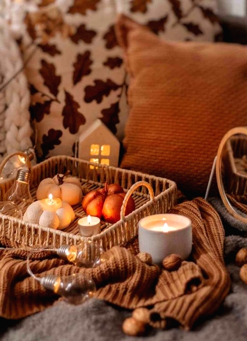 a woven tray with bulbs and lights, candles and faux pumpkins is a lovely fall or Thanksgiving decoration
