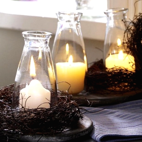 bottles with pillar candles wrapped with vine and on trays are amazing for styling your space for Thanksgiving in a rustic way