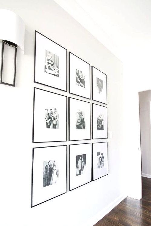 a chic and elegant grid gallery wall with black and white family pics and thin black frames is an adorable solution