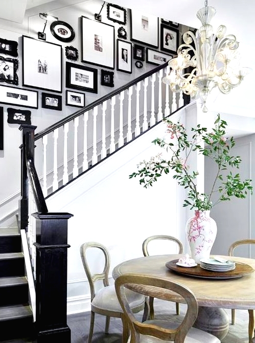 a vintage gallery wall with mismatching refined and modern black frames adds elegant and chic feel to the space