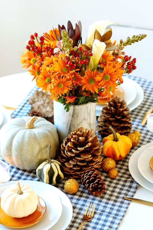 a beautiful and all-natural Thanksgiving centerpiece of mini and larger pumpkins, pinecones, bold blooms and berries is awesome