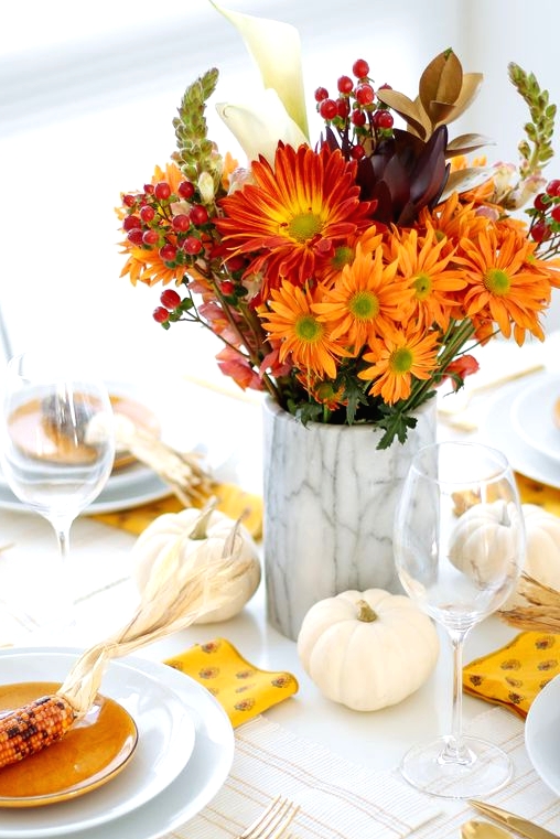 a lovely Thanksgiving centerpiece of white pumpkins, a marble vase with super bold blooms and berries is awesome
