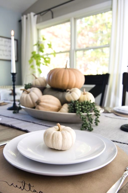 a natural Thanksgiving place setting with a cardboard placemat, elegant and simple porcelain and a mini white gourd is a cool idea