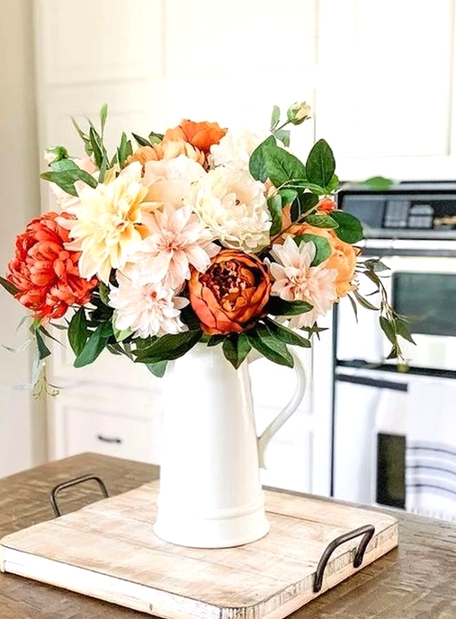 a cool floral Thanksgiving centerpiece of blush, peachy and orange blooms plus greenery is a simple and lovely idea