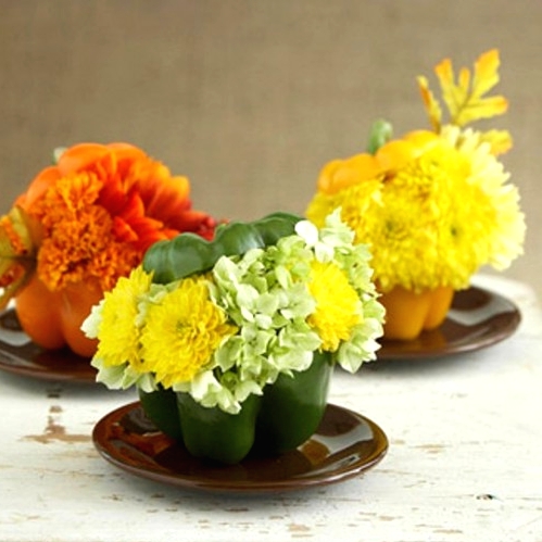super bright mini Thanksgiving centerpieces made of bold peppers filled with blooms that match in color look fun and super cool