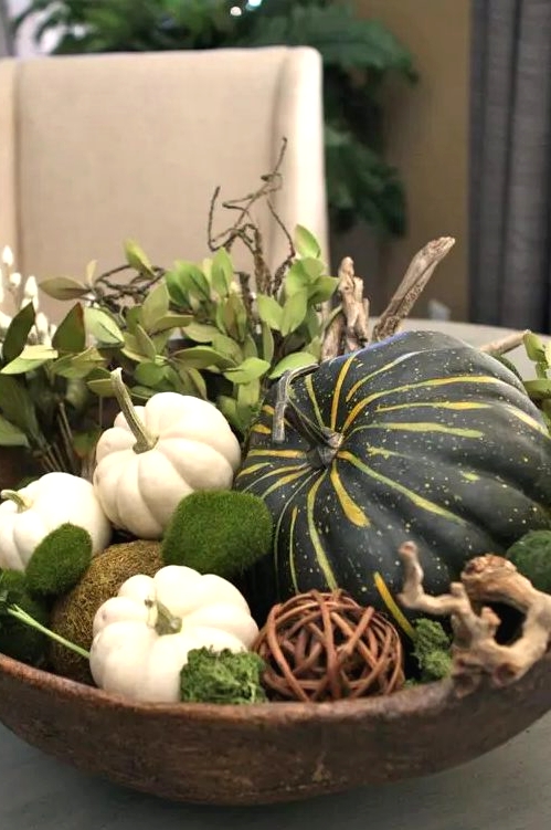 a pretty Thanksgiving centerpiece of a wooden box, pumpkins, moss, a vine ball and greenery is a rustic or a woodland solution