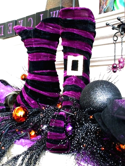 black and purple striped witches' stockings and boots, with black ornaments are a fun idea to style your mantel for Halloween