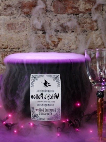 a witches' cauldron with purple smoke and lights is a chic and cool Halloween decoration that is out of the box