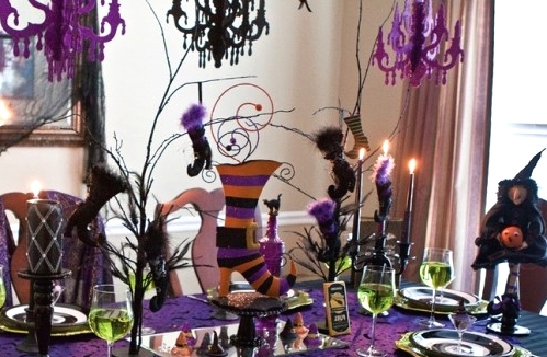 a super bright green, purple, black and orange Halloween tablescape with witches' legs, hats and other catchy decor
