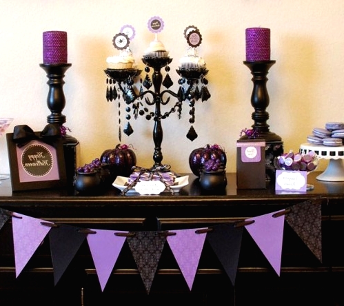 an elegant vintage black and purple Halloween sweets table with candles, cupcakes, sweets, candles and buntings is a very cool and fresh solution