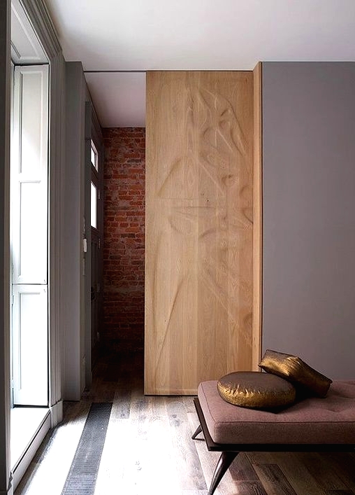a gorgeous wooden pocket door with a pattern is a beautiful decor feature that separates the space in a cool way