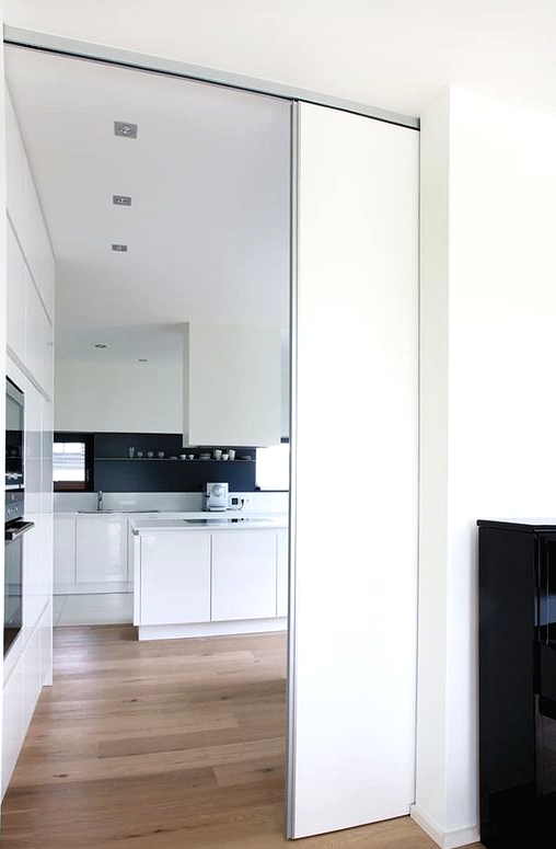 a sleek white pocket door is a cool and minimalist way to separate the spaces without spoiling any interior and look