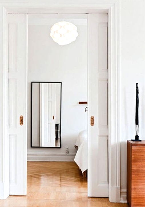 refined white paned pocket doors are a perfect way to divide the spaces in a stylish way and save a lot of room