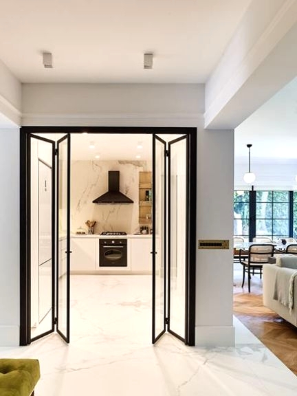 glass and black frame folding doors are a great idea to separate the kitchen that has no windows from the rest of the house and bring light inside