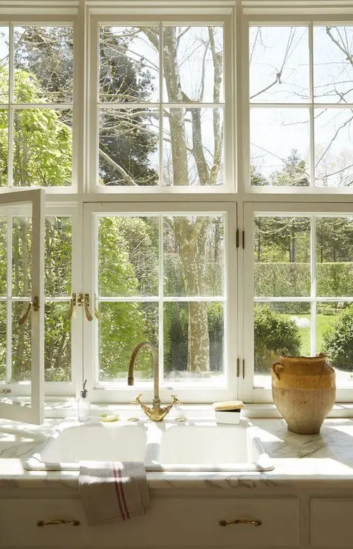 a big white French window is an ideal fit for a Provence-styled kitchen done in neutrals, it brings a lot of natural light and cool views