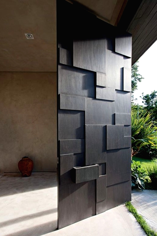 a modern sculptural and geometric oversized black front door is a cool idea for any modern or contemporary home