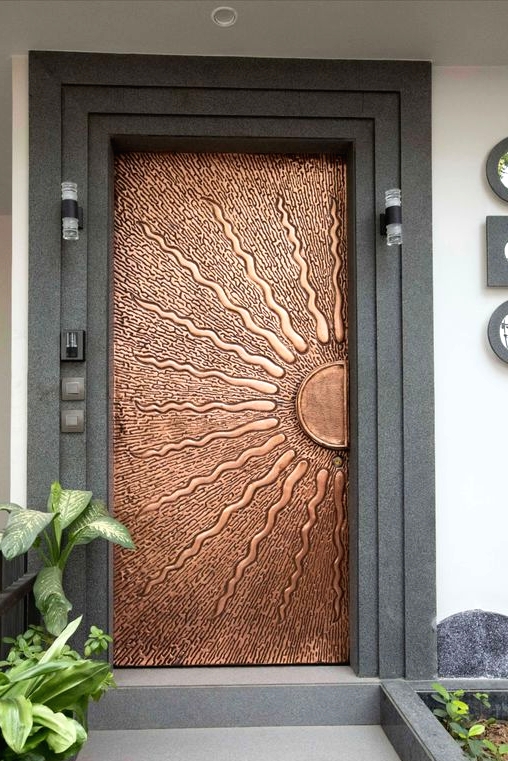 a unique copper door with a sun portrayed is a gorgeous idea to make a statement with its color and this image