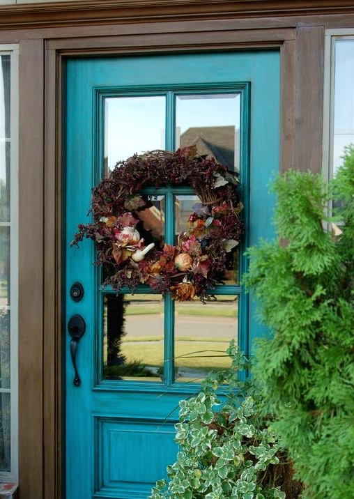 a turquoise glass front door is a refined idea that brings color and looks very chic and stylish, ideal for a refined house