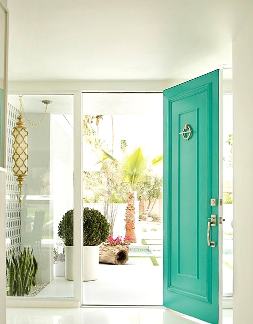 a white entrance accented with a bold green front door and gold touches are perfect for a mid-century modern house