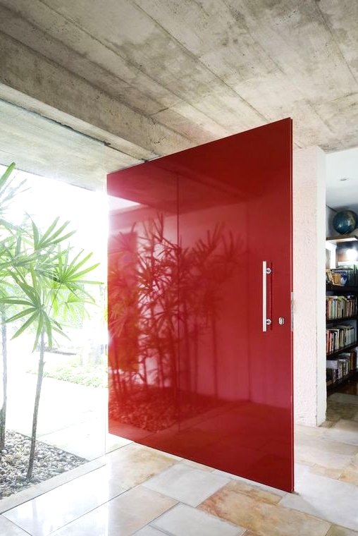 an oversized bold red super sleek front door with a usual handle is a fantastic idea for a mid-century modern home